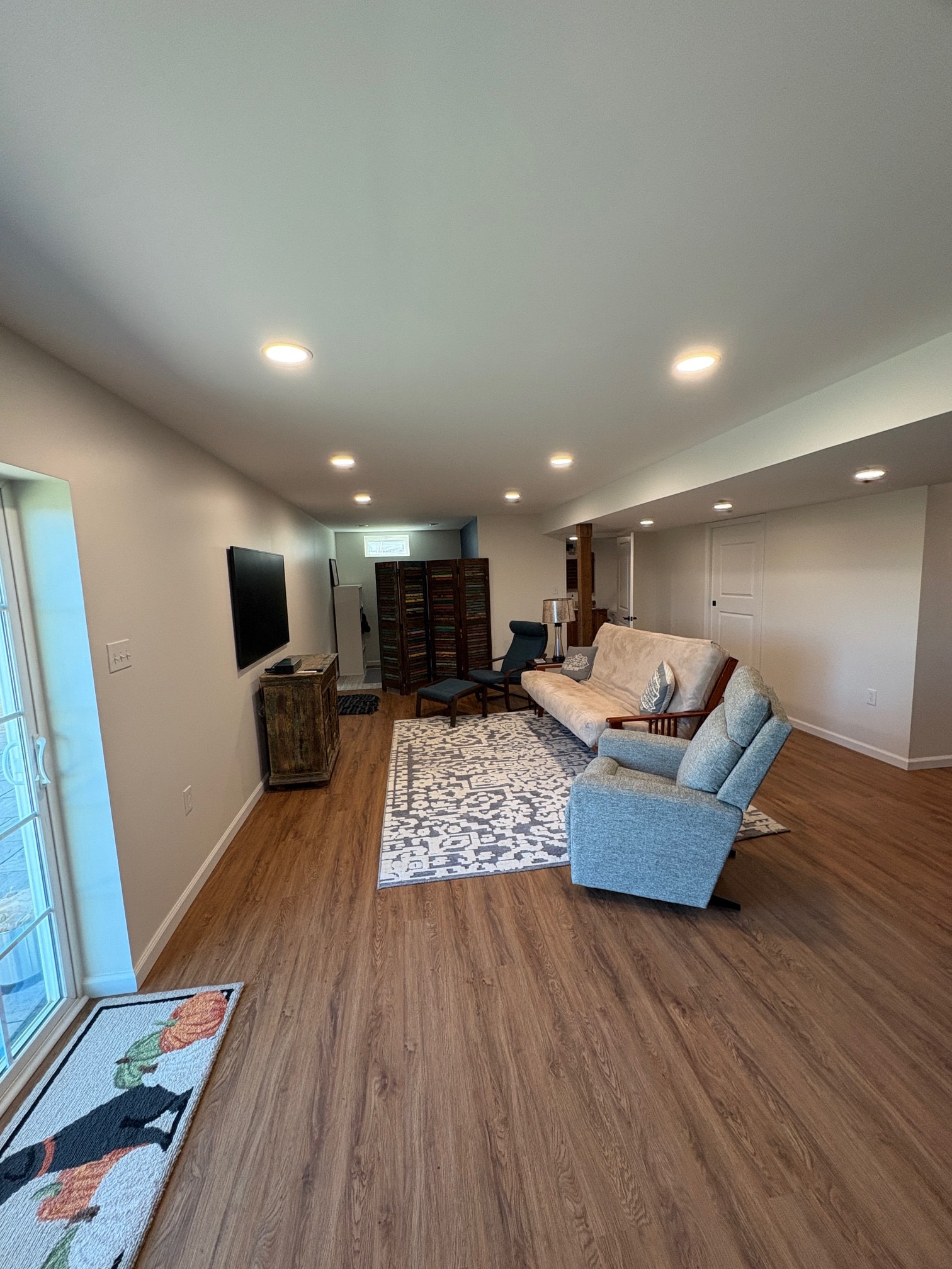 Finished basement living area with hardwood floors and recessed lighting