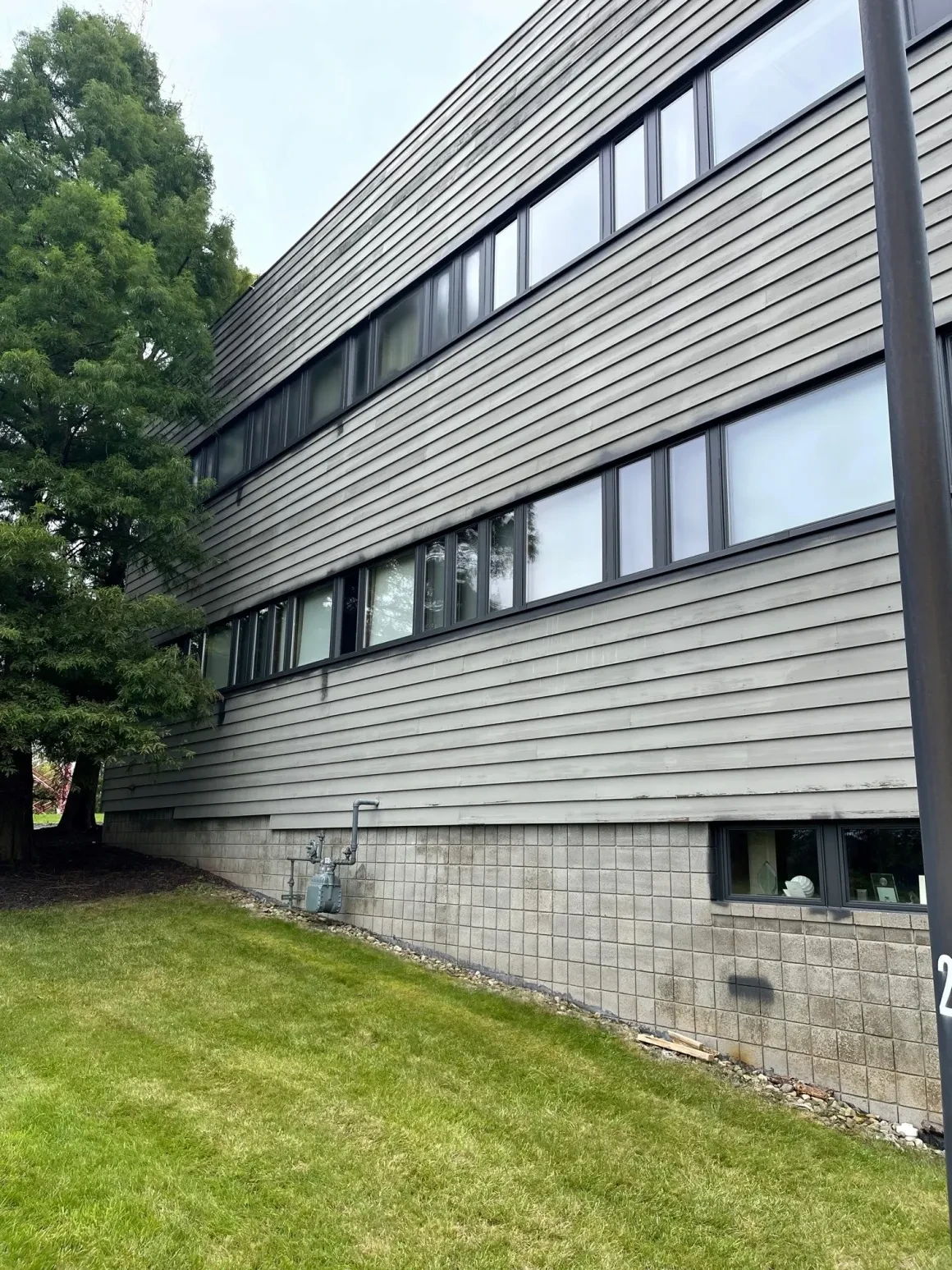 Completed commercial building exterior with new dark horizontal metal panel siding