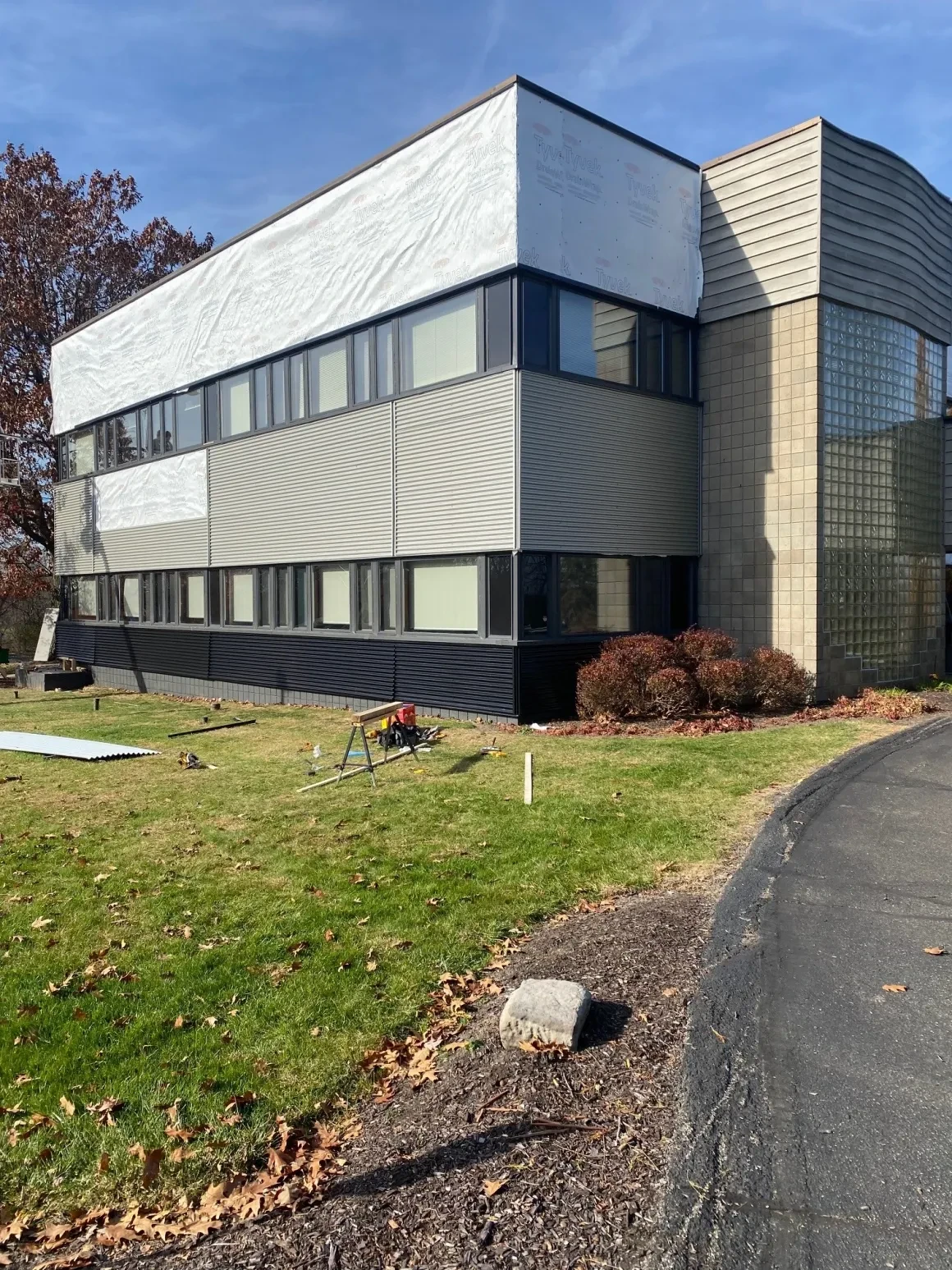 Commercial building during renovation with Tyvek wrap and new siding partially installed