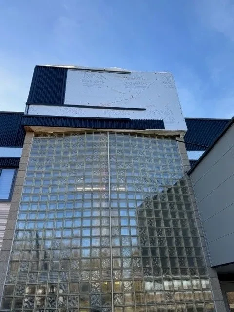 Glass block facade and upper Tyvek wrap during commercial building renovation
