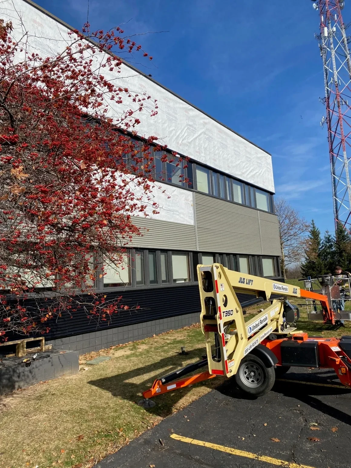 JLG boom lift and Tyvek wrap on commercial building during active renovation