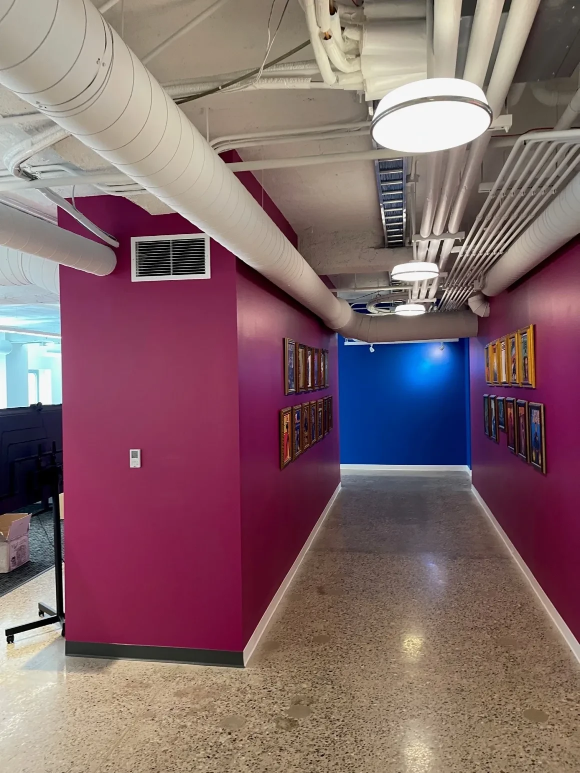 Bright office breakroom with long tables, white chairs, and natural light