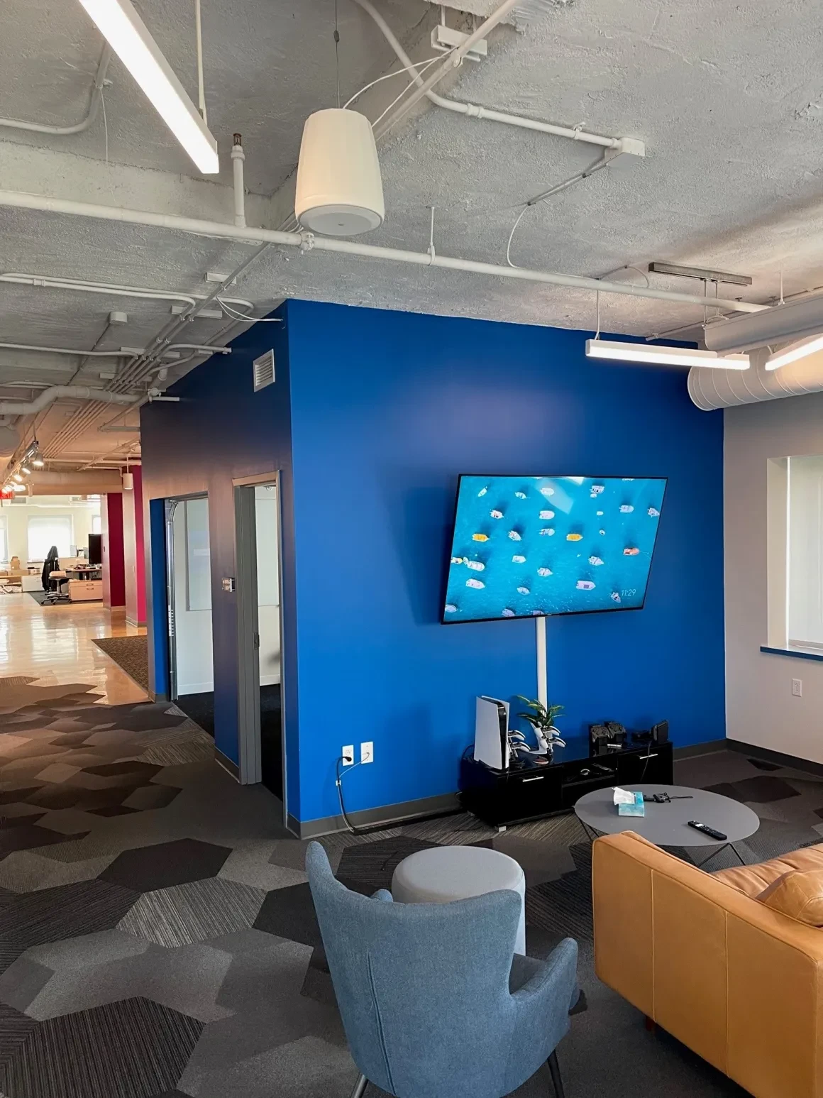 Blue accent wall with whiteboard and glass partition in open office