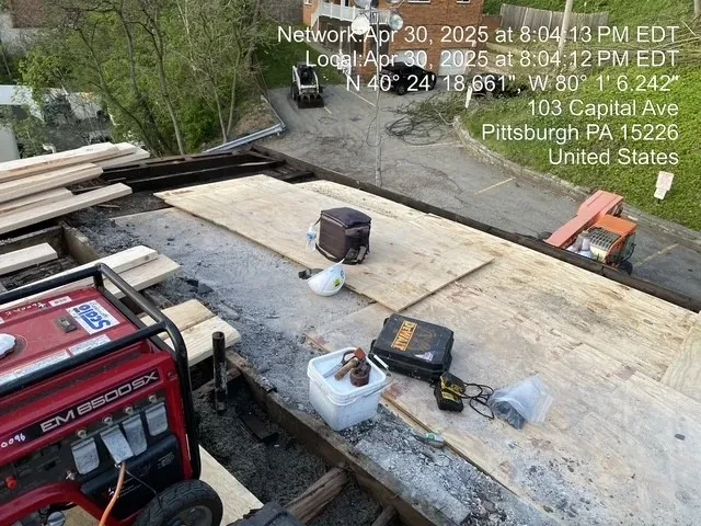 New plywood decking installed on roof with DeWalt tools and hard hat at 103 Capital Ave