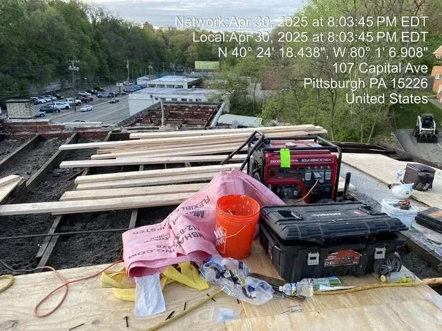 Roofing materials and tools staged on new decking at 103 Capital Ave