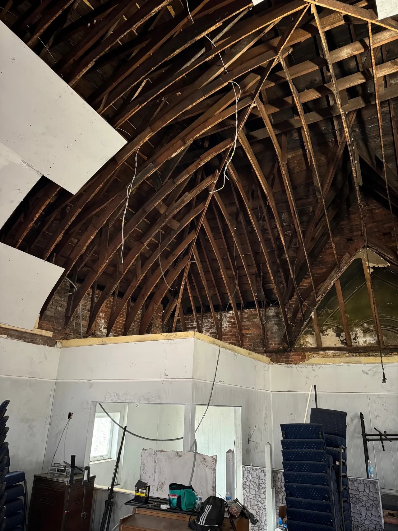 Exposed arched timber roof framing before new ceiling installation